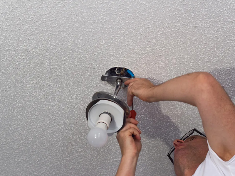 worker of platinum electric fixing the ceiling lights of a house in rigby id - electrician in rigby id
