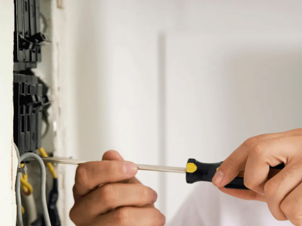 worker of platinum electric repairing the breaker box - rigby id electrician