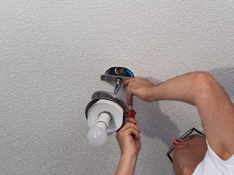 worker of platinum electric fixing the ceiling lights of a house in rexburg id